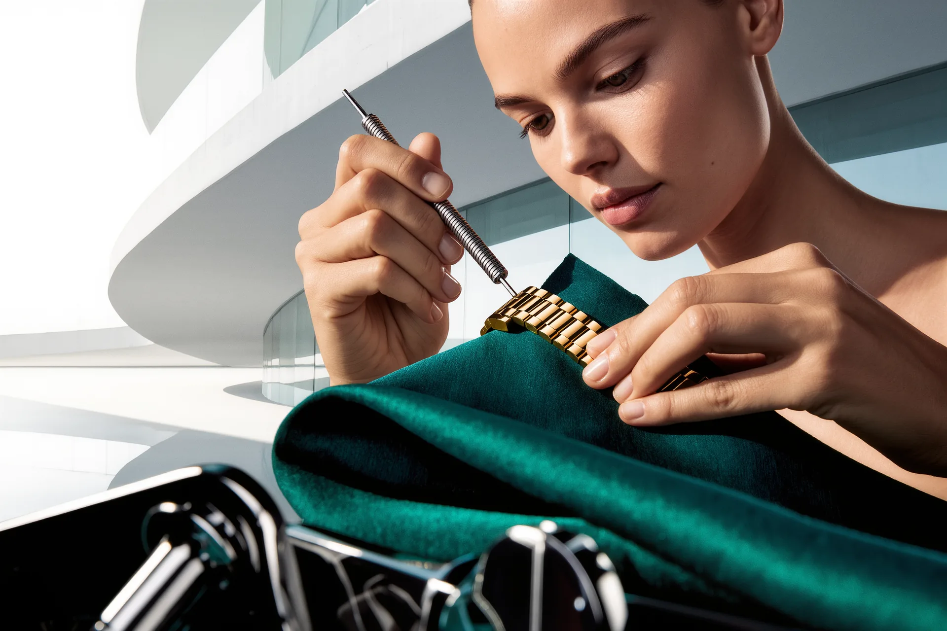 Des mains changent le bracelet d'une montre avec un outil à barrettes sur un chiffon