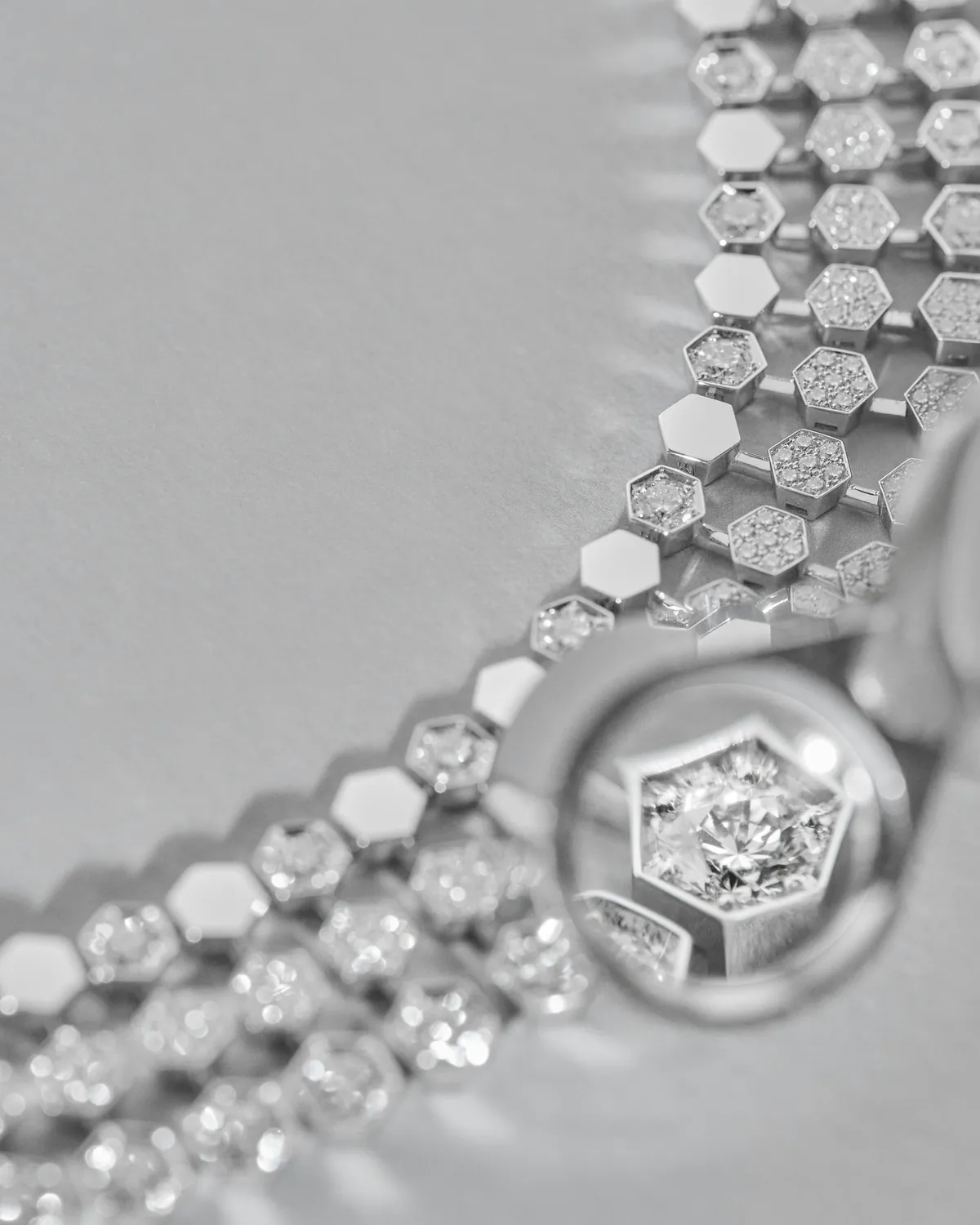 Maillons alvéolés du collier Bee de Chaumet observés à la loupe, diamant serti au cœur d'un hexagone
