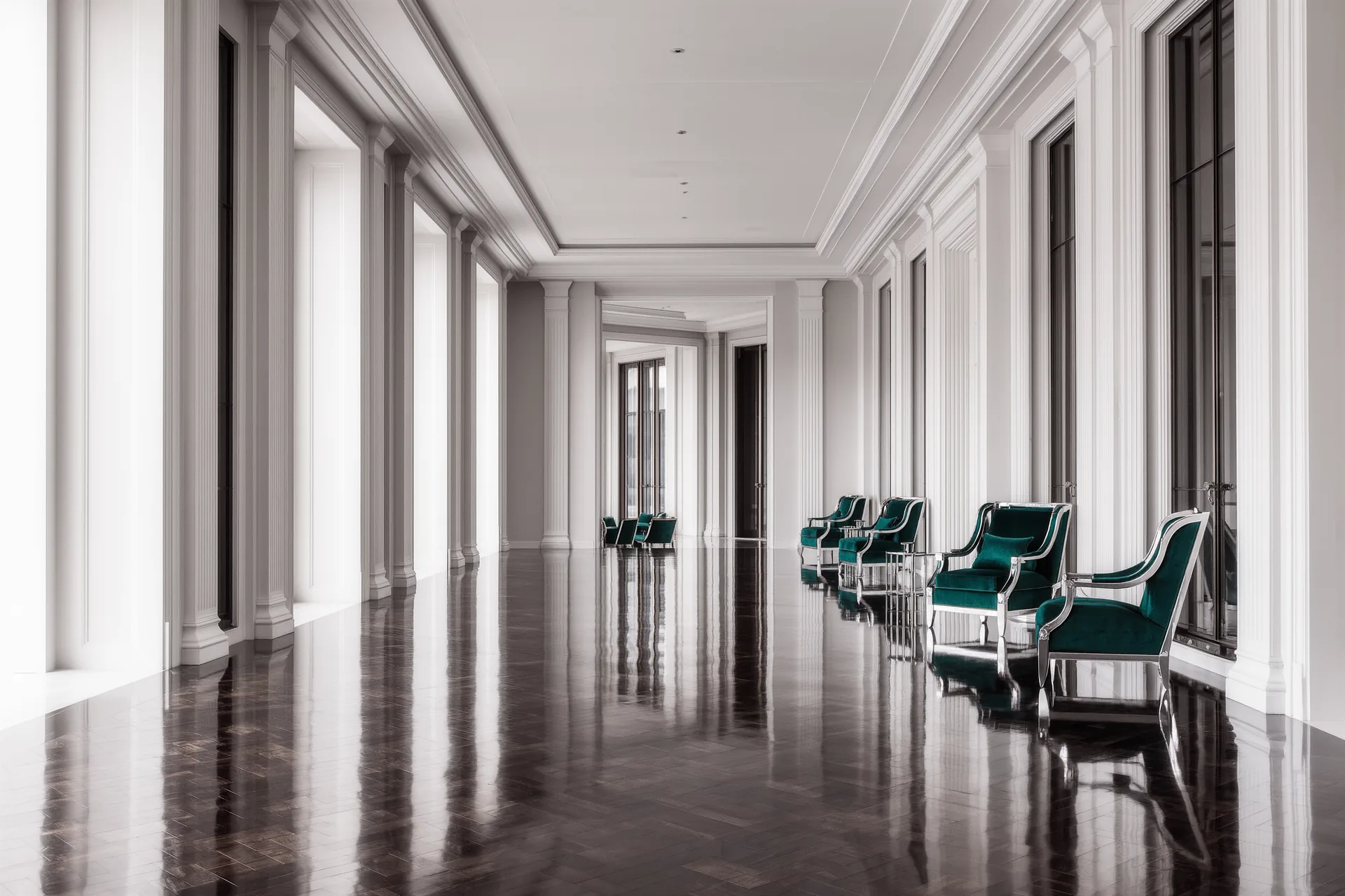 Hall d'un grand hôtel au petit matin, lumière douce, fauteuils vides et parquet ciré