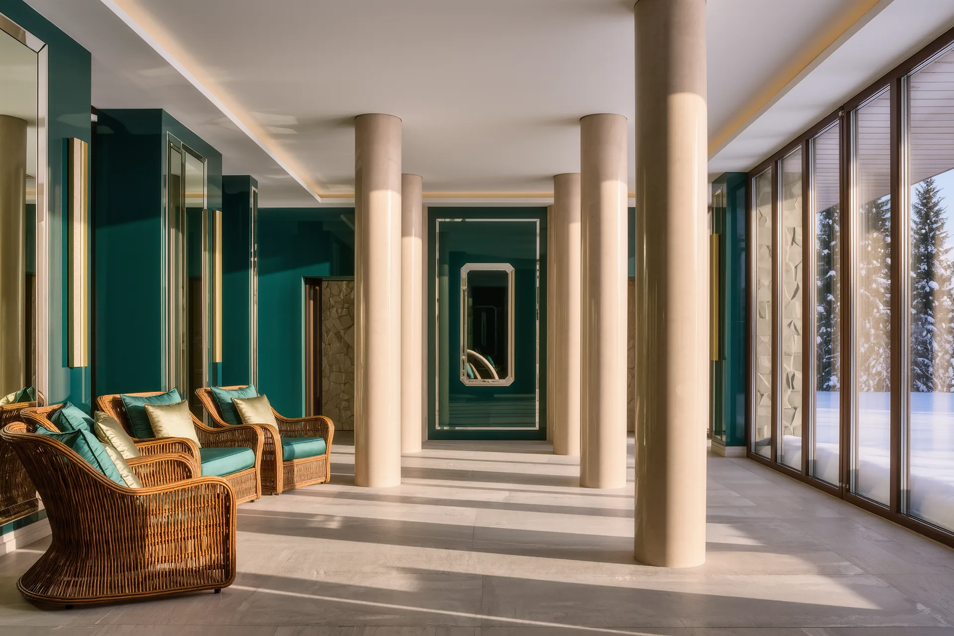 Une galerie thermale ancienne aux colonnes claires, fauteuils de rotin et lumière tamisée d'un matin d'hiver.