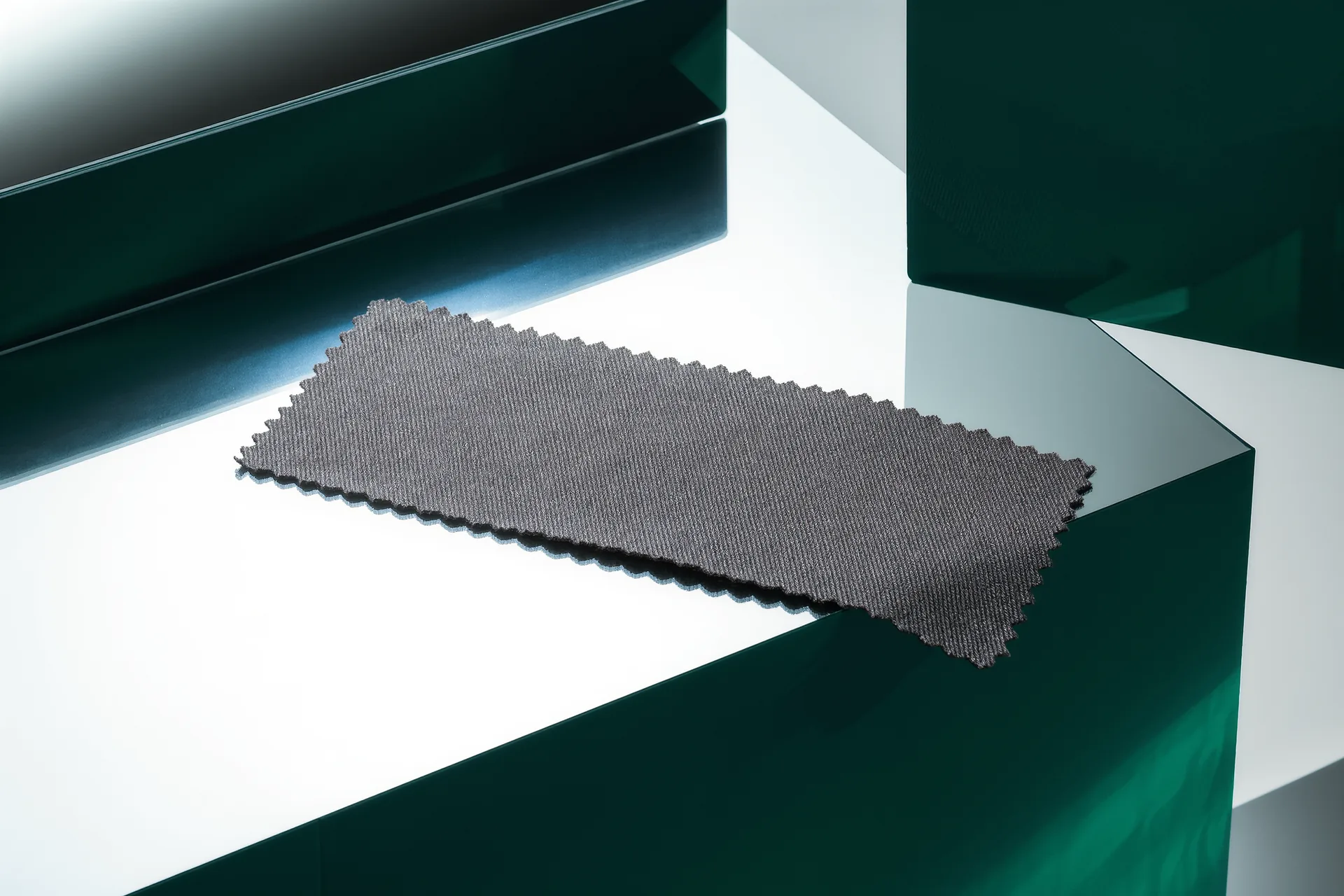 Coupon de laine worsted gris anthracite à fine rayure, surface lisse sous une lumière d'atelier