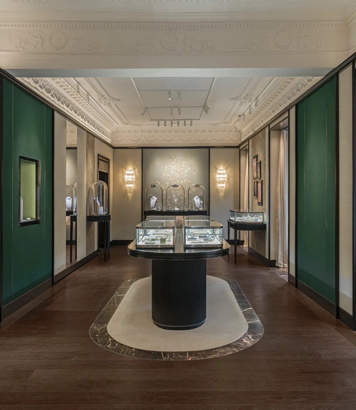 Salle principale de la boutique Van Cleef & Arpels à Madrid, vitrines de haute joaillerie et panneaux verts sous un plafond mouluré